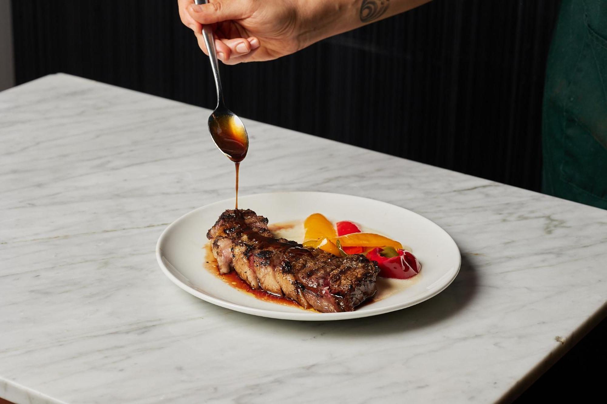 The Inchcolm By Ode Hotels Брисбен Экстерьер фото A steak being drizzled with steak sauce