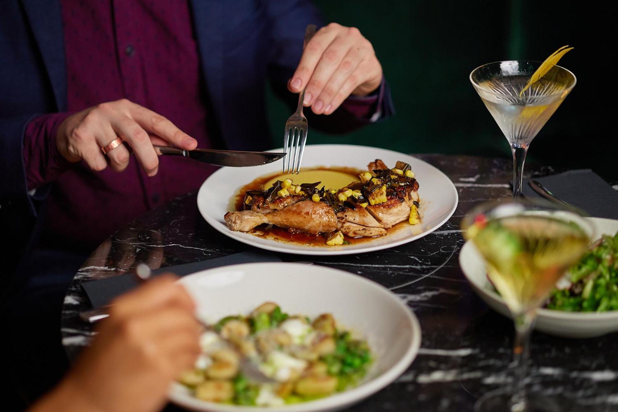 The Inchcolm By Ode Hotels Брисбен Экстерьер фото A woman using a knife and fork to cut into a meal